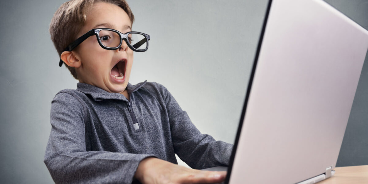 Surprised kid sitting at laptop