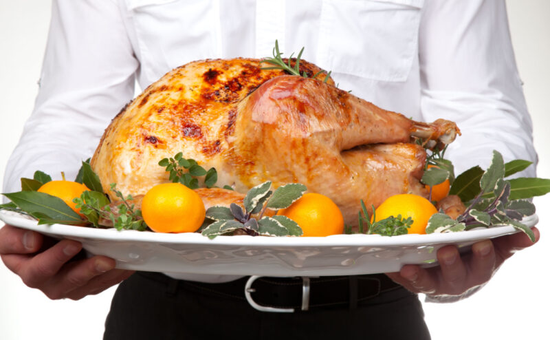 Person serving roasted turkey